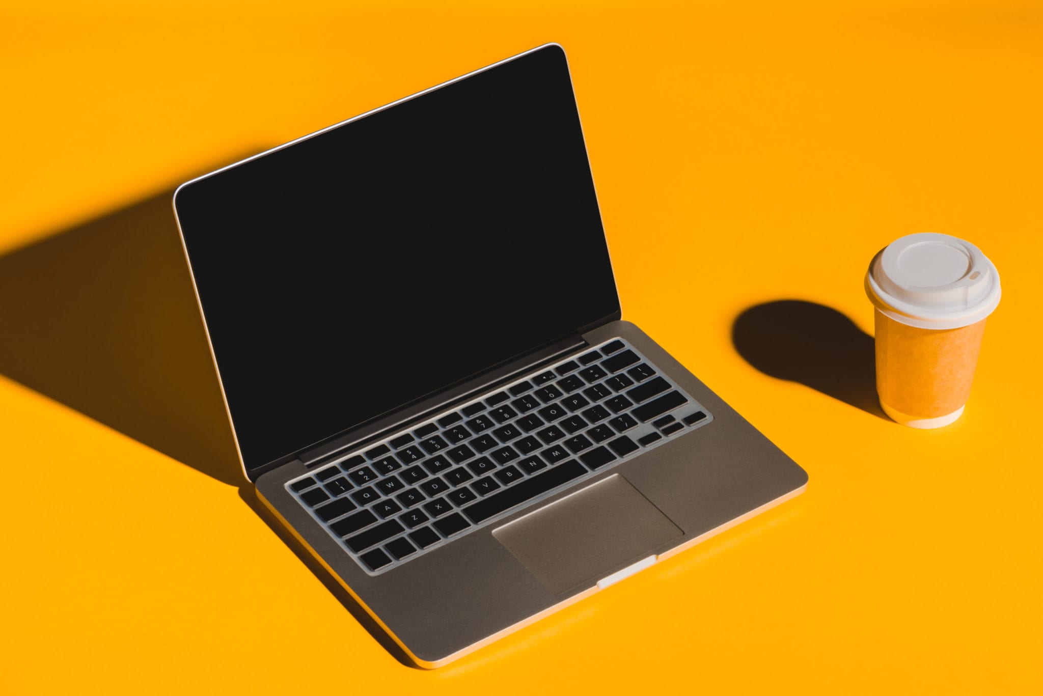 coffee and laptop on yellow background