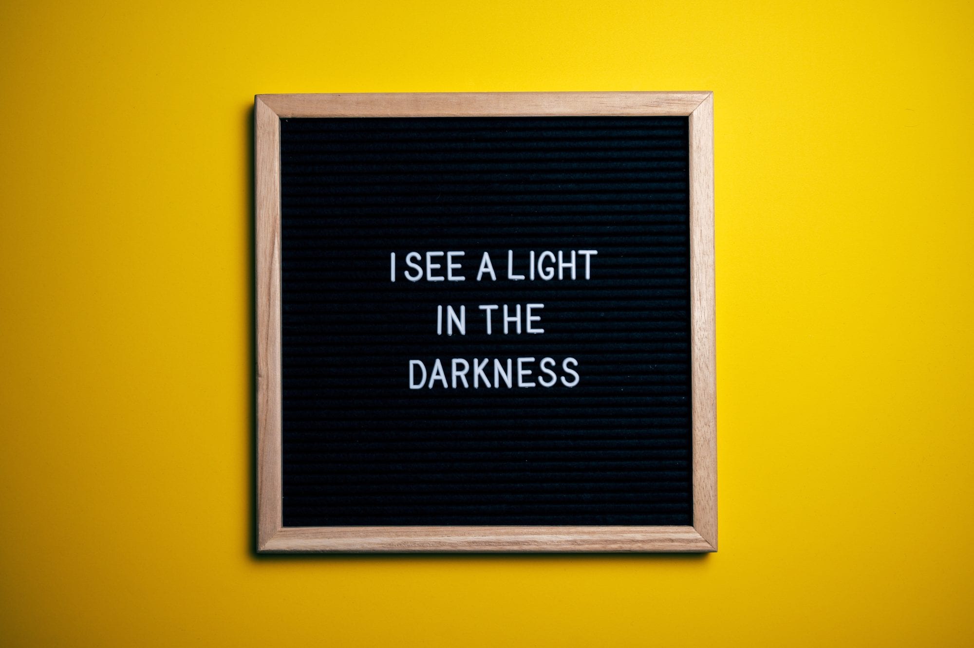 yellow background with image in frame saying I see a light in the darkness